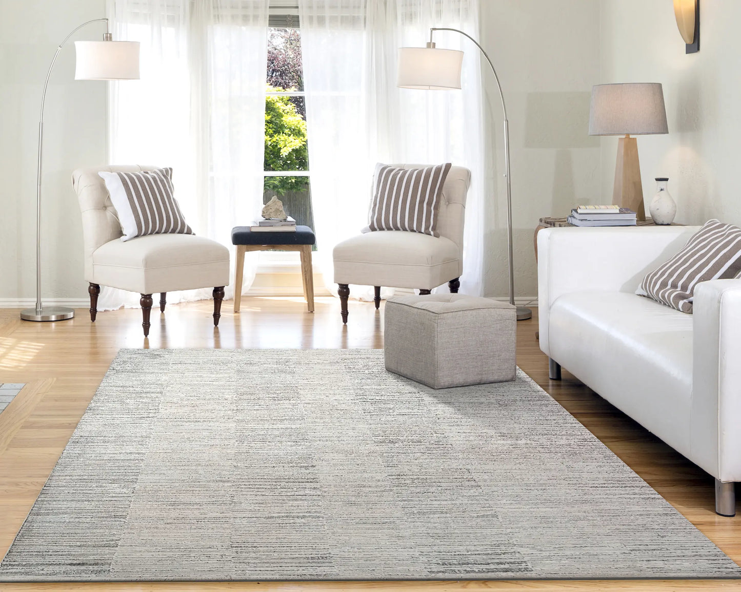 A rectangular rug with a modern abstract geometric pattern in shades of beige in a white living room.
