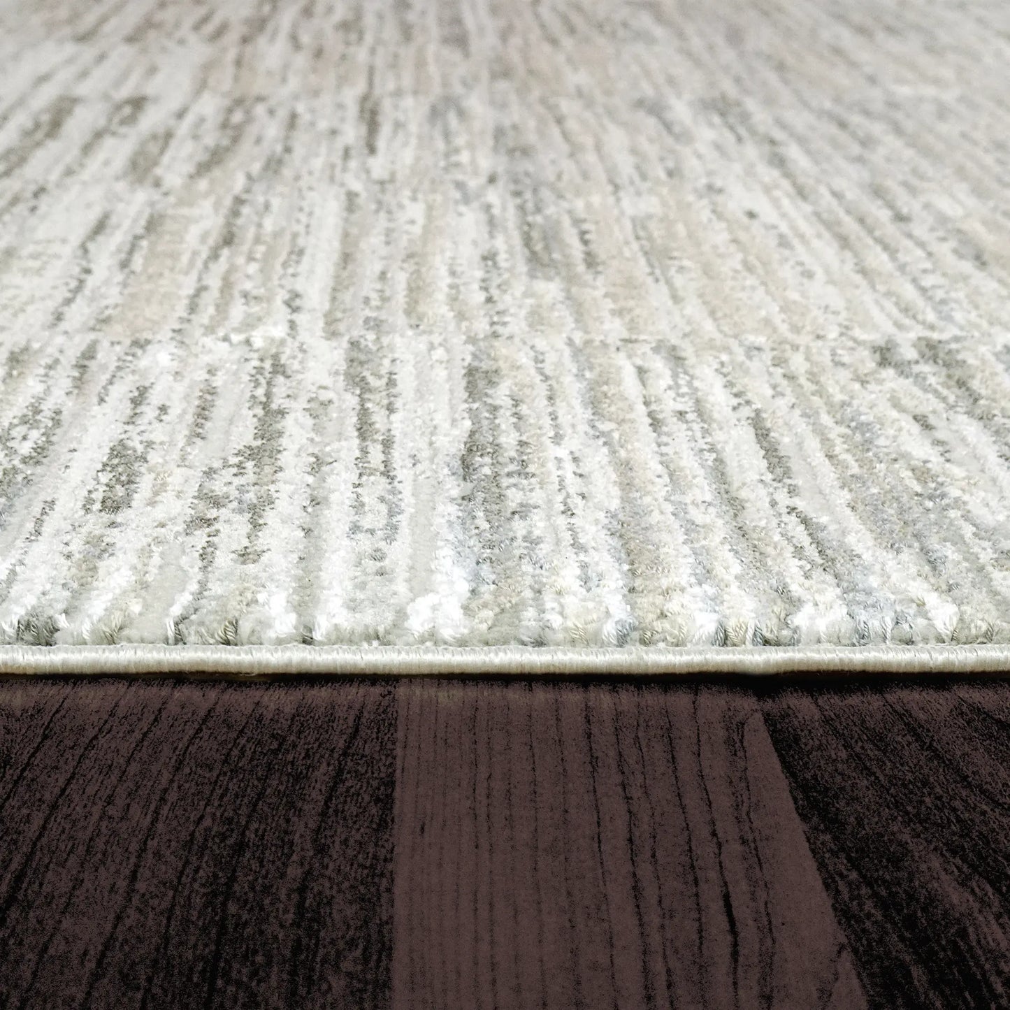 A closeup of a rectangular rug with a modern abstract geometric pattern in shades of beige.