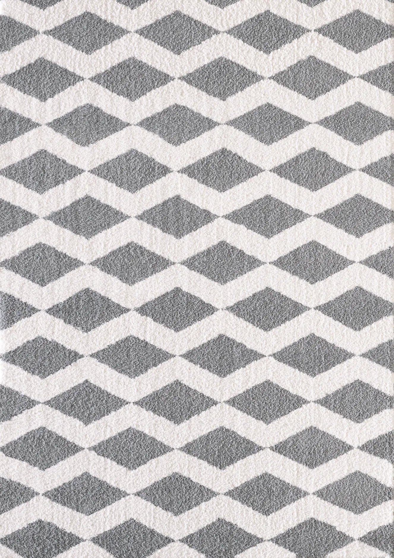 A rectangular rug with a contemporary geometric pattern in grey and white shades, featuring a plush microfiber pile.