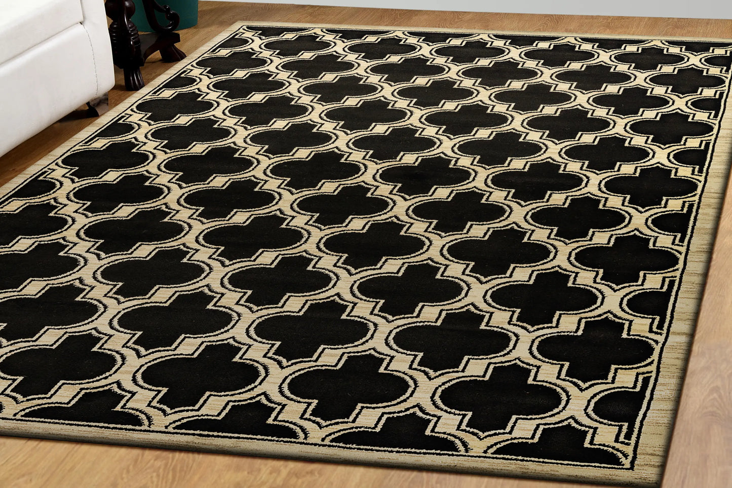 A rectangular traditional wool rug with a geometric pattern in beige and black colors on a wooden floor.