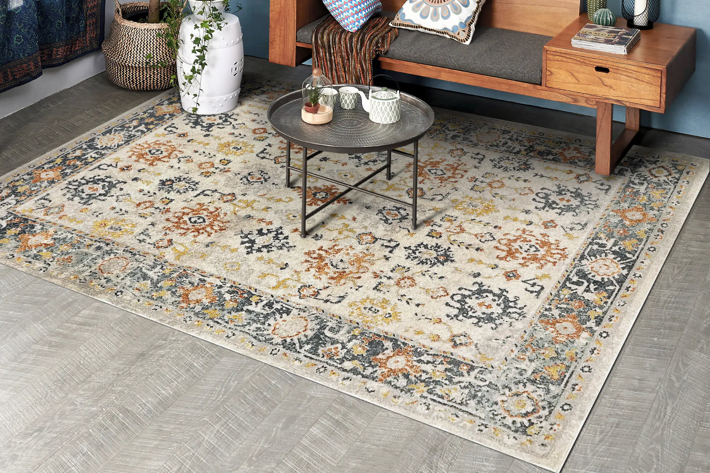 A Zahara rectangular traditional wool runner with a floral pattern in shades of beige, brown, gold, and gray with a coffee table on top.